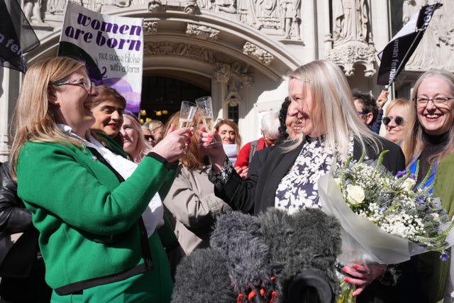 A group of women celebrating with glasses of champagne outside the Supreme Court