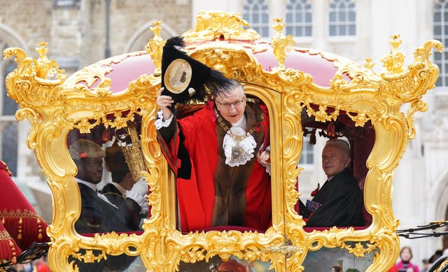 Alastair King, the 696th Lord Mayor of the City of London, waves from the state coach during the Lord Mayor’s Show in the City of London