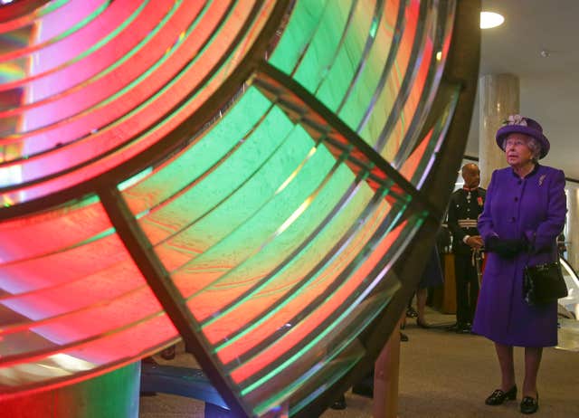 The Queen looks at an optic from the decommissioned Orfordness Lighthouse in Suffolk built by Chance Brothers of Smethwick and installed in 1913 (Daniel Leal-Olivas/PA)