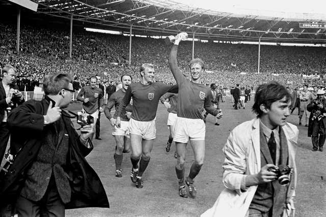 Charlton holds the Jules Rimet trophy aloft
