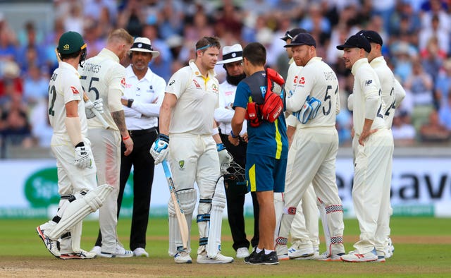 Steve Smith, centre, is assessed after being hit on the head