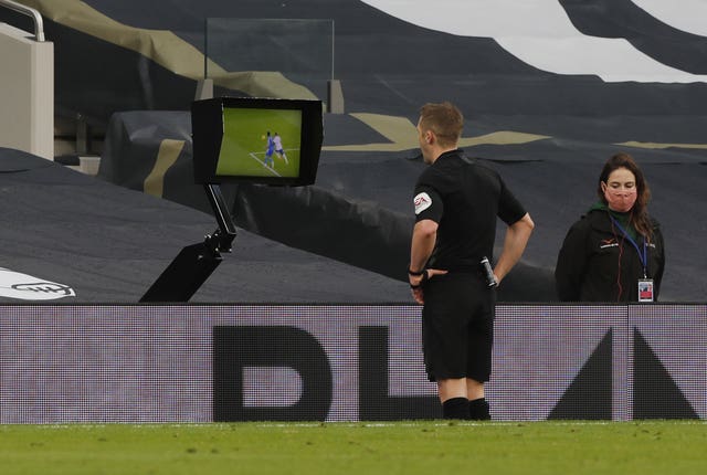 Referee Craig Pawson reviews Serge Aurier's foul before awarding a penalty