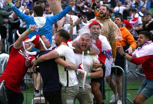 England fans in Manchester celebrate as the team advances to the last four (Martin Rickett/PA).