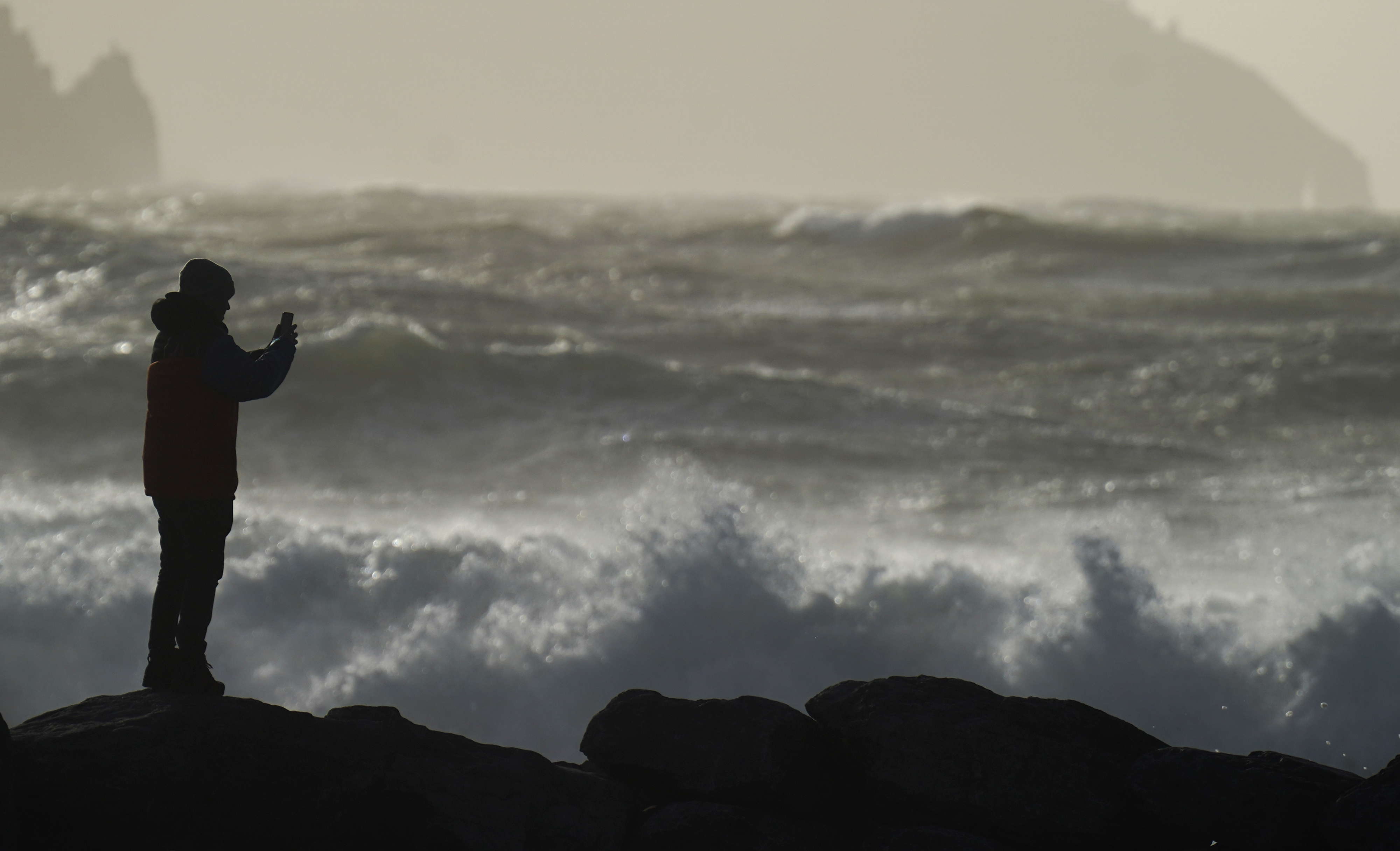 A person watching high waves in Doolin in County Clare