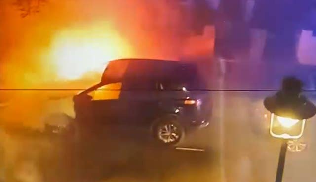 A screengrab from a video of firefighters tackling a burning car