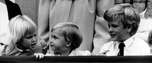 Zara Phillips talks to cousin Prince William (centre) with brother Peter Phillips on the balcony of Buckingham Palace in 1984 (PA)