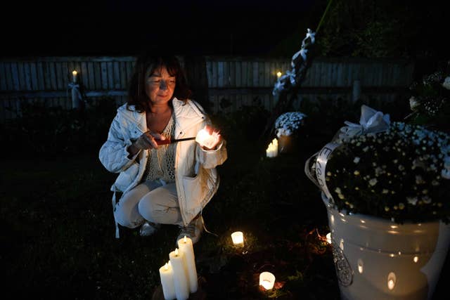 A person lights a candle during a vigil in Co Louth for Mark and Louise O’Connor and their son Evan