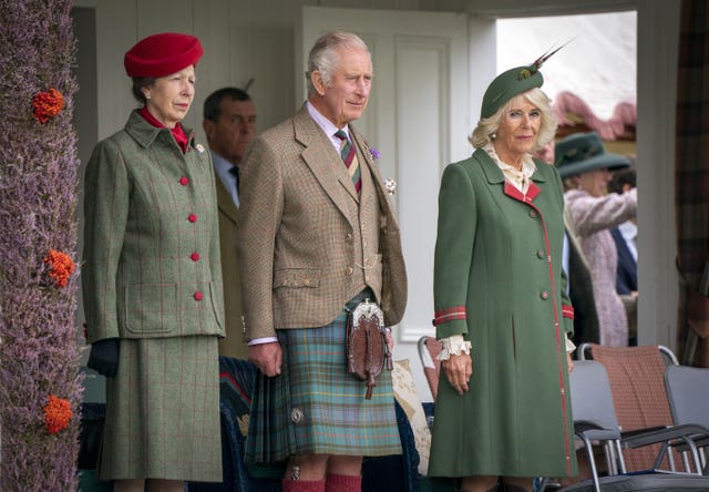 Anne and Camilla stand either side of Charles, who wear a kilt, at the Braemar Gathering highland games