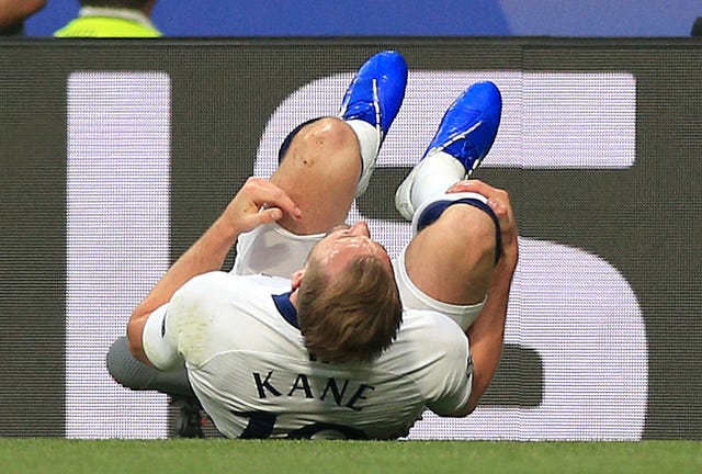 Harry Kane rolls on the ground after a challenge