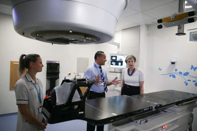 Theresa May is shown the advanced radiotherapy system during her visit to Addenbrooke’s (Daniel Leal-Olivas/PA)