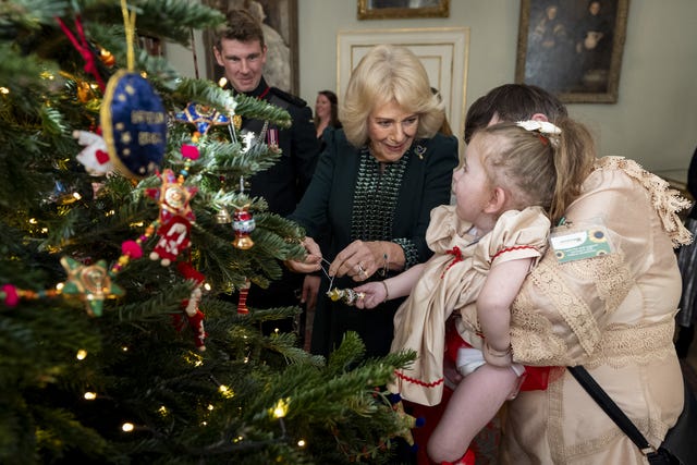 The Queen and Dolce place a decoration on the Christmas tree at Clarence House