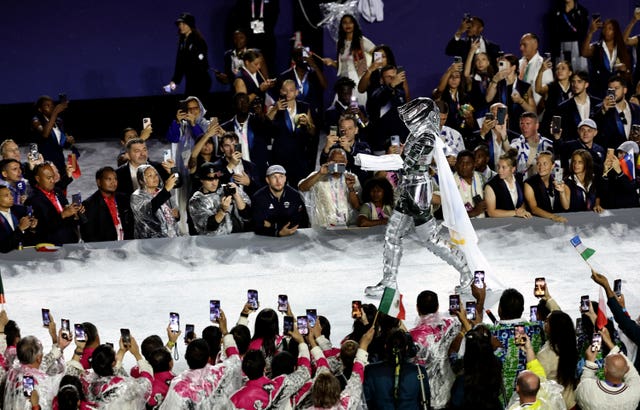 A horsewoman carries the flag of the IOC