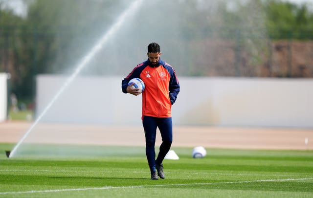 Manchester United manager Ruben Amorim walks with a ball under his arm during a training session