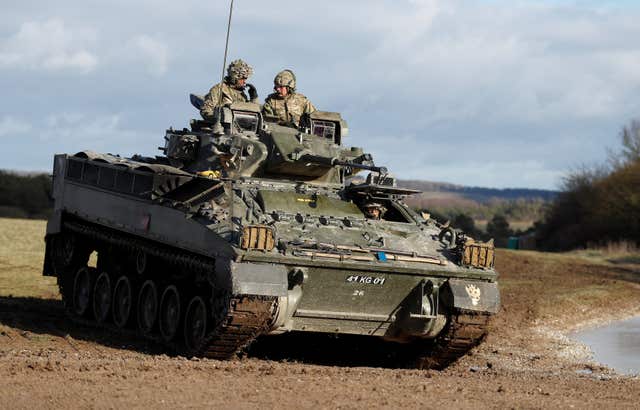 The Prince of Wales (back right) takes a ride on a Warrior infantry armoured vehicle during a visit to the Mercian Regiment to mark 10 years as its colonel-in-chief. (Peter Nicholls/PA)