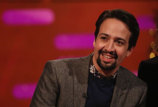 Lin-Manuel Miranda smiles while seated