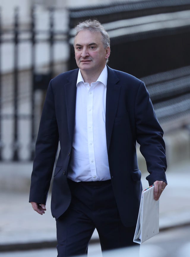 Sir Chris Wormald walking outside, carrying a white folder