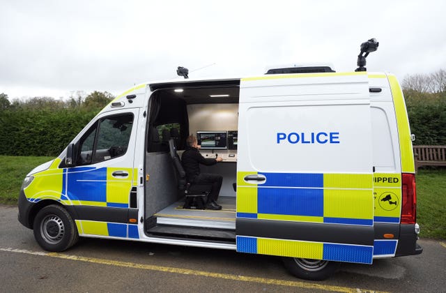 A police officer views a camera feed from inside a live facial recognition demonstration
