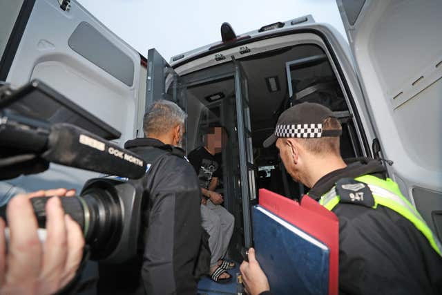 A suspect is put in the back of a police van following a raid at an address in Stockton, Teesside, as part of a crackdown on people trafficking and serious sexual offences. (Owen Humphreys/PA)