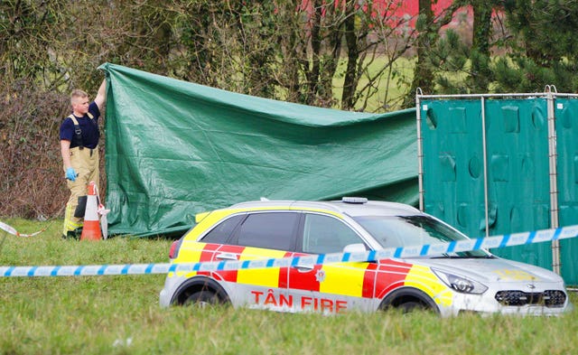 Firefighters erecting screens at the scene of the incident