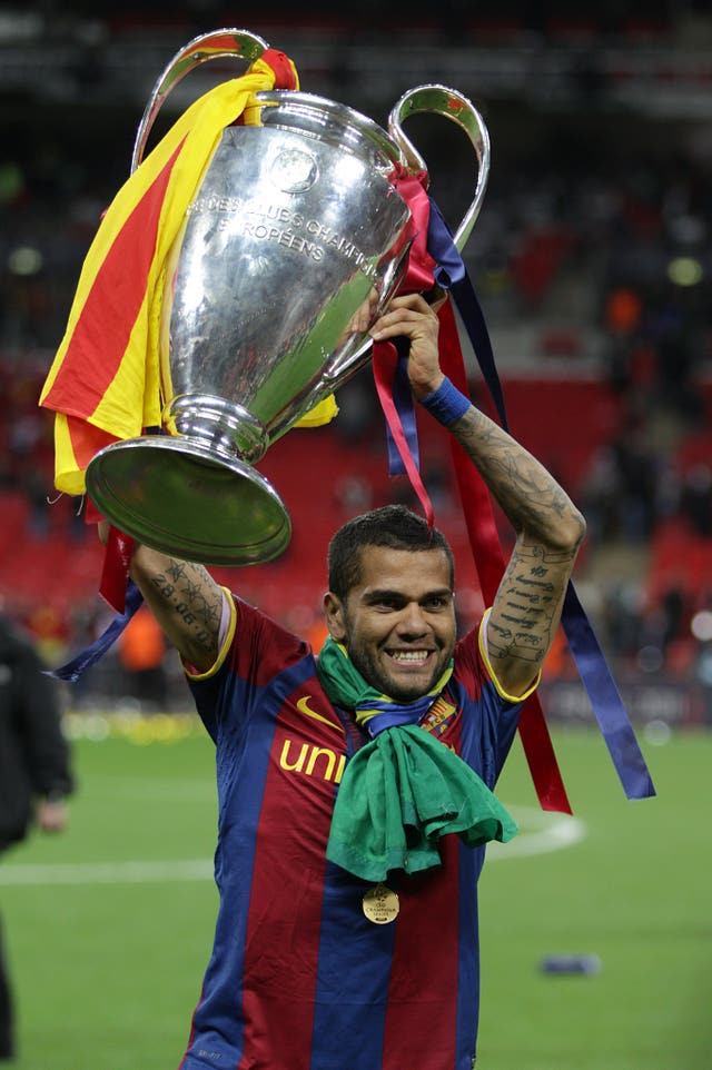 Dani Alves celebrates with Champions League trophy. (PA)
