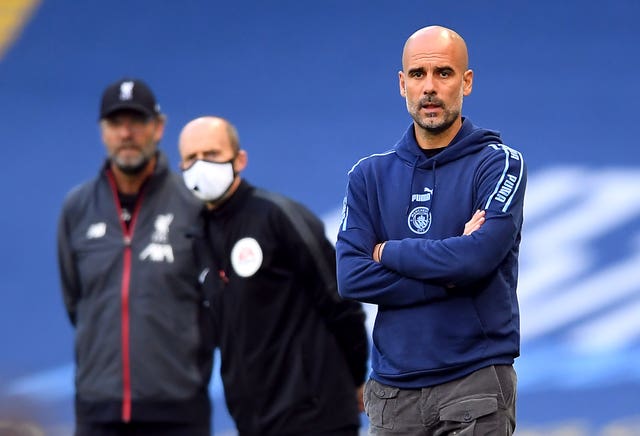 Masked fourth official Mike Dean, centre, peers past Pep Guardiola during Manchester City's thrashing of champions Liverpool. City gave Jurgen Klopp's Reds a belated reminder of their power as they thrashed their newly-crowned successors 4-0 at the Etihad Stadium in early July