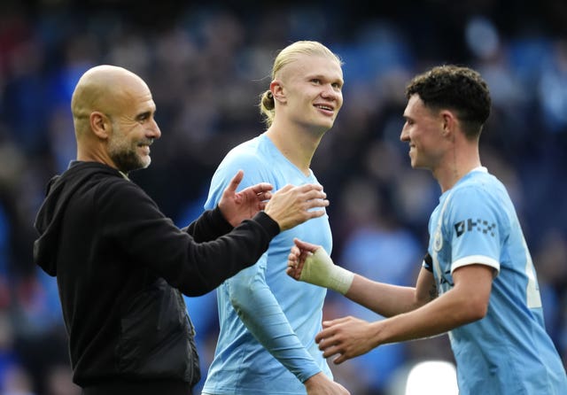 Pep Guardiola, left, celebrates victory with Erling Haaland, centre, and Phil Foden