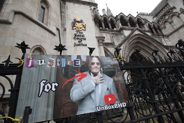 A poster on the railings outside the Royal Courts of Justice in London