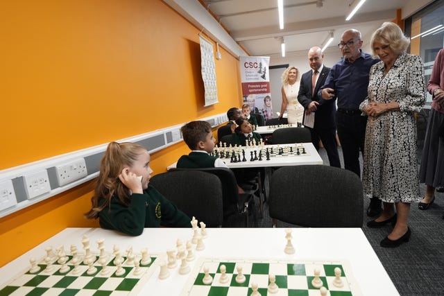 Camilla watches children play chess during a visit to Liverpool