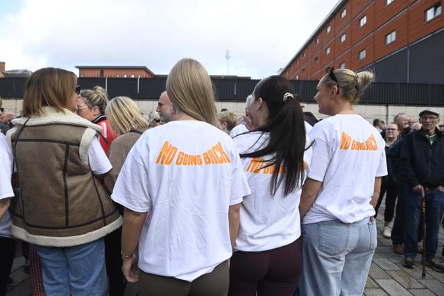 People seen from behind with 'No going back' on their T-shirts
