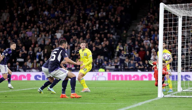 Lyndon Dykes (left) scores