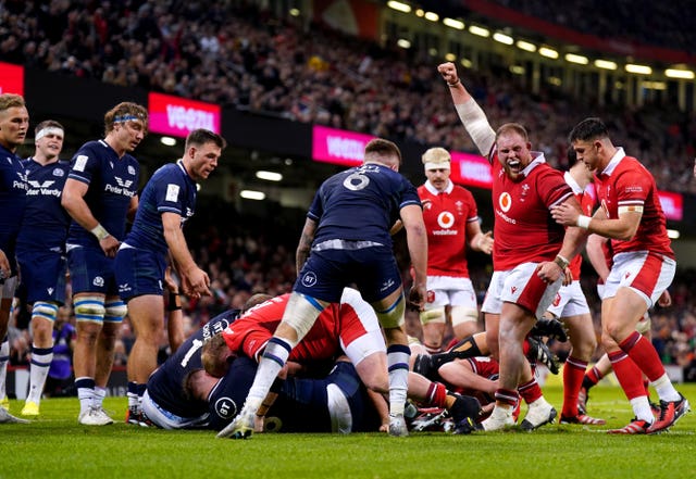 Wales celebrate as James Botham touches down at the bottom of a pile of players