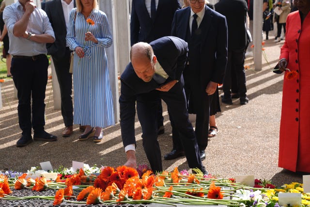 The Prince of Wales laying flowers as he attends a 7/7 memorial service