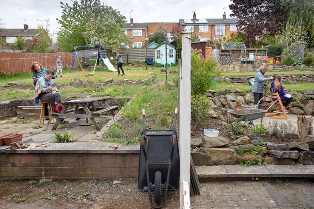 A photo issued by Historic England from its Picturing Lockdown Collection of neighbours in adjacent gardens on Hallamshire Drive, Sheffield, giving haircuts, taken by Historic England photographer Alun Bull