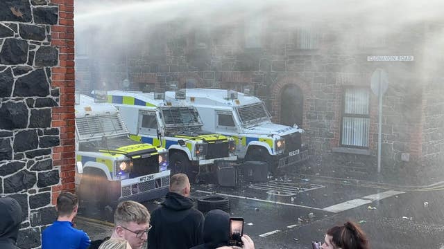 Police officers using a water cannon