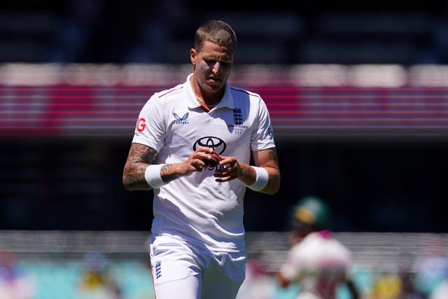 Brydon Carse inspecting the ball