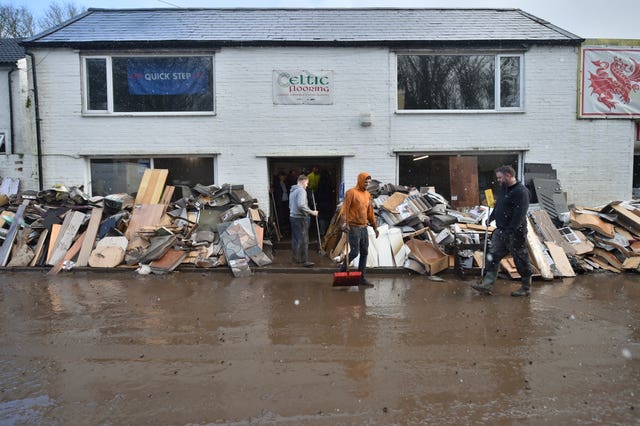 Staff members clean up outside the Celtic Flooring store in Nantgarw, South Wales