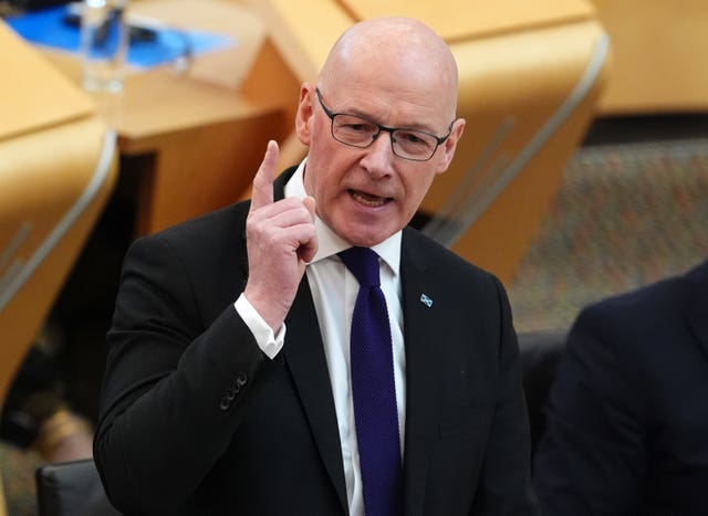 John Swinney pointing while speaking in Parliament