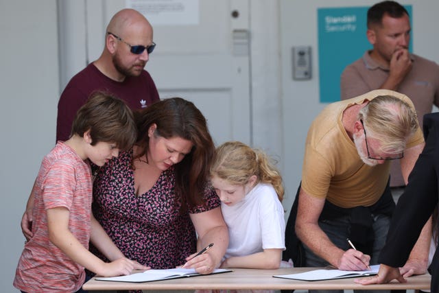 People signing condolence books