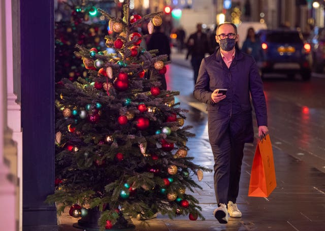 Shoppers pass Christmas light displays on New Bond Street in central London