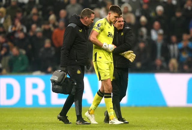 Newcastle goalkeeper Nick Pope (centre) is helped off