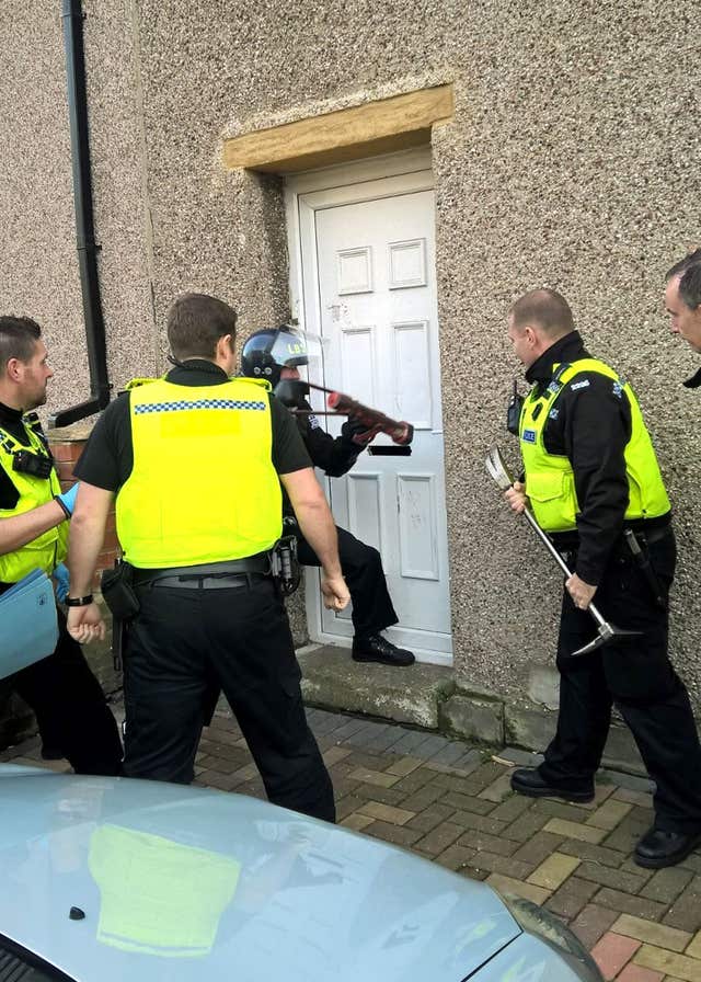Police entering a property in Blyth, Northumberland, which belongs to Harjit Bariana (Northumbria Police/PA)
