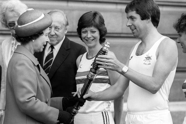 Queen Elizabeth II hands over the baton for the Commonwealth Games relay to Brendan Foster in June 1982