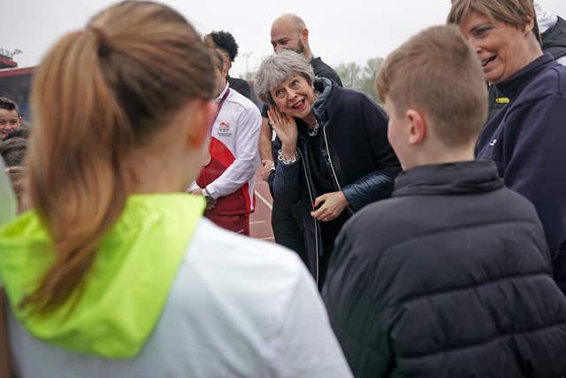Theresa May (centre) talks with young athletes during her visit to Alexander Stadium in Perry Park in Perry Barr, Birmingham (Christopher Furlong/PA)