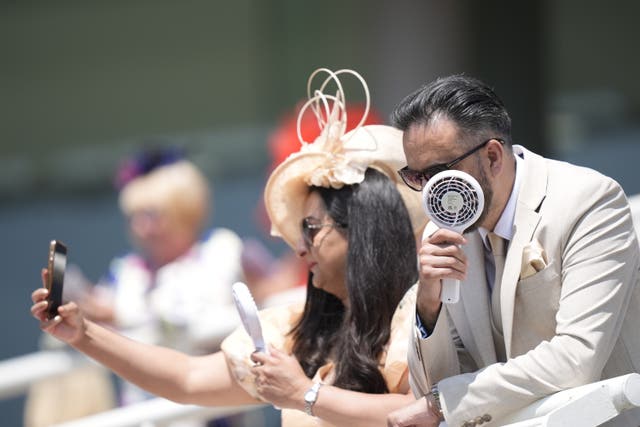 Racegoers using fans to cool themselves down on day three of Royal Ascot