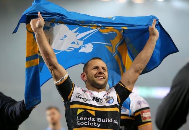 Former Leeds Rhinos captain Rob Burrow celebrates with a flag