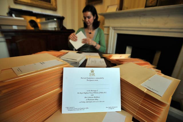 A member of the Lord Chamberlain’s Office at Buckingham Palace in London, inserts the invitations into envelopes, for the wedding of Prince William and Kate Middleton (John Stillwell/PA)