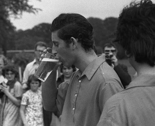 Black and white photo of Charles drinking a pint at Cowdray Park