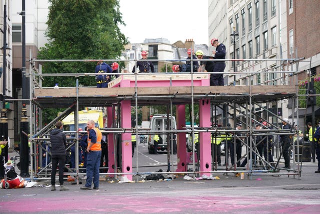 Workers remove a large pink structure Extinction Rebellion activists erected to block a junction in London