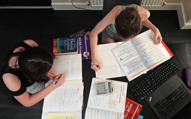 View from above of two girls doing their school work at home during the pandemic