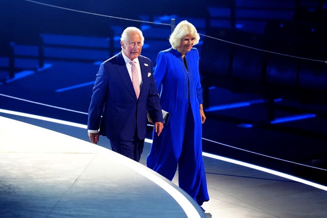 Charles and Camilla making their way down a ramp before taking up seats in the royal box